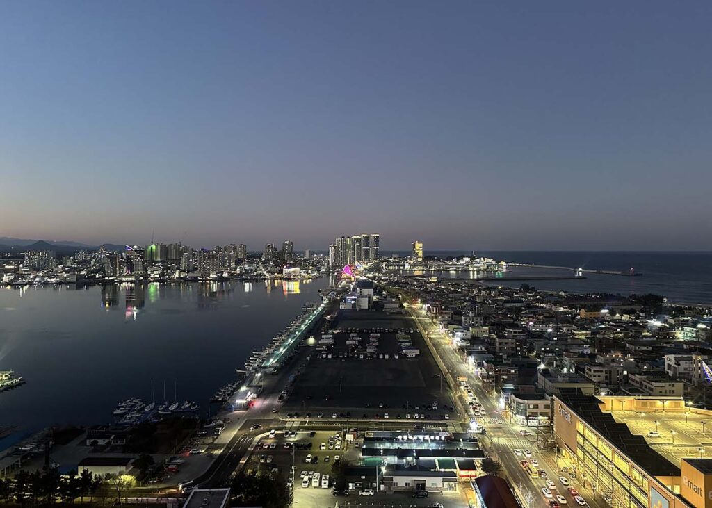 Vista no nosso quarto no Mari Vista Hotel. Do lado direito o mar, do lado esquerdo a lagoa. Em frente vários restaurantes, lojas, um emart (supermercado).